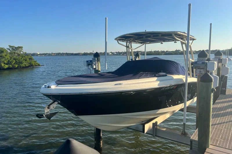 Slide: The Image of 2017 Chris-Craft Calypso 26 boat docked on a lift by the water. - 3