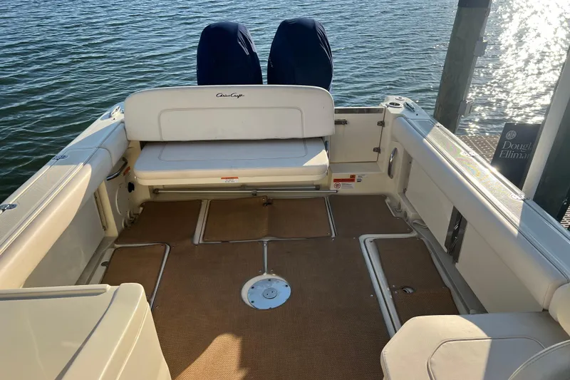 Slide: The Image of 2017 Chris-Craft Calypso 26 boat interior with seating, docked by the water. - 4