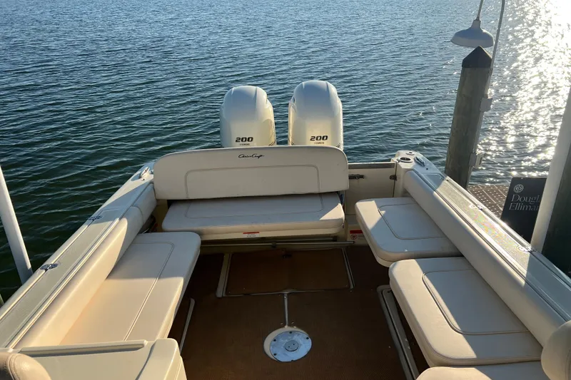 Slide: The Image of 2017 Chris-Craft Calypso 26 boat with twin 200 horsepower engines docked by the water. - 6