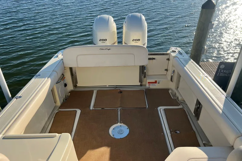 Slide: The Image of 2017 Chris-Craft Calypso 26 boat with twin 200 horsepower engines, docked on calm water. - 7