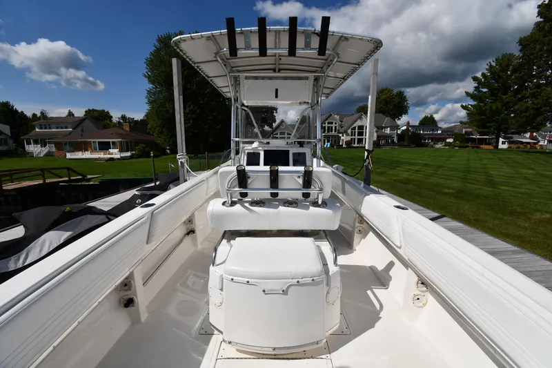 Slide: The Image of 2000 Fountain 31 Tournament Edition boat with open deck and seating, docked near green lawn. - 10