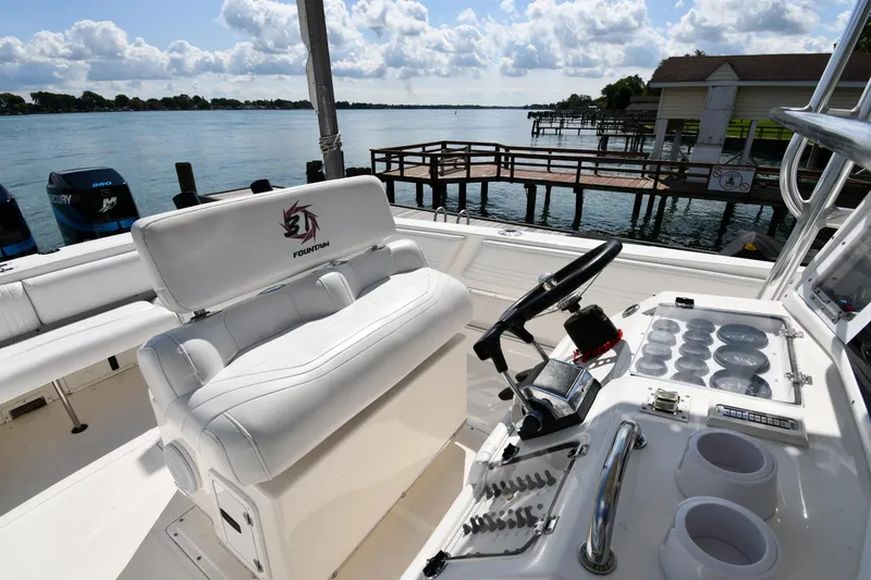 Slide: The Image of 2000 Fountain 31 Tournament Edition boat interior with helm, white seating, and water view. - 16