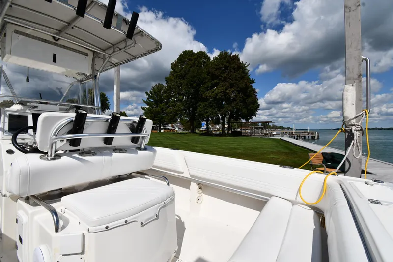 Slide: The Image of 2000 Fountain 31 Tournament Edition boat docked by a scenic lakeside with trees and clouds. - 18