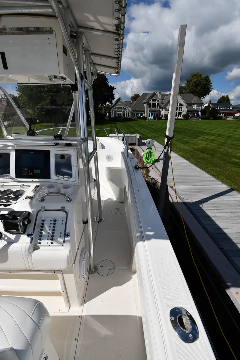 Slide: The Image of 2000 Fountain 31 Tournament Edition boat docked by a lakeside with houses in the background. - 25