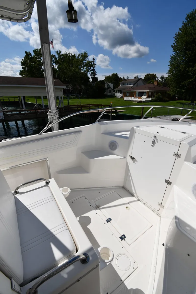 Slide: The Image of 2000 Fountain 31 Tournament Edition boat interior with seating, docked near waterfront homes. - 29