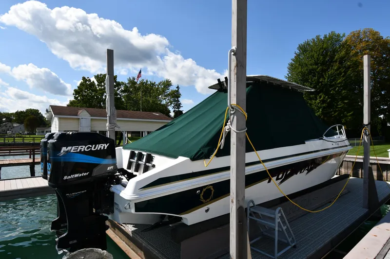 Slide: The Image of 2000 Fountain 31 Tournament Edition boat with Mercury outboard, docked under a clear sky. - 49
