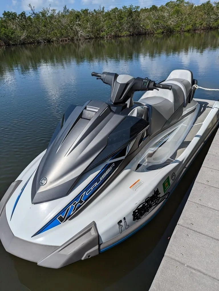 Slide: The Image of 2019 Yamaha WaveRunner VX Cruiser jet ski docked on calm water. - 2