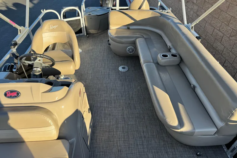 Slide: The Image of 2023 Ranger Reata 200F boat interior with beige seating and steering console. - 17