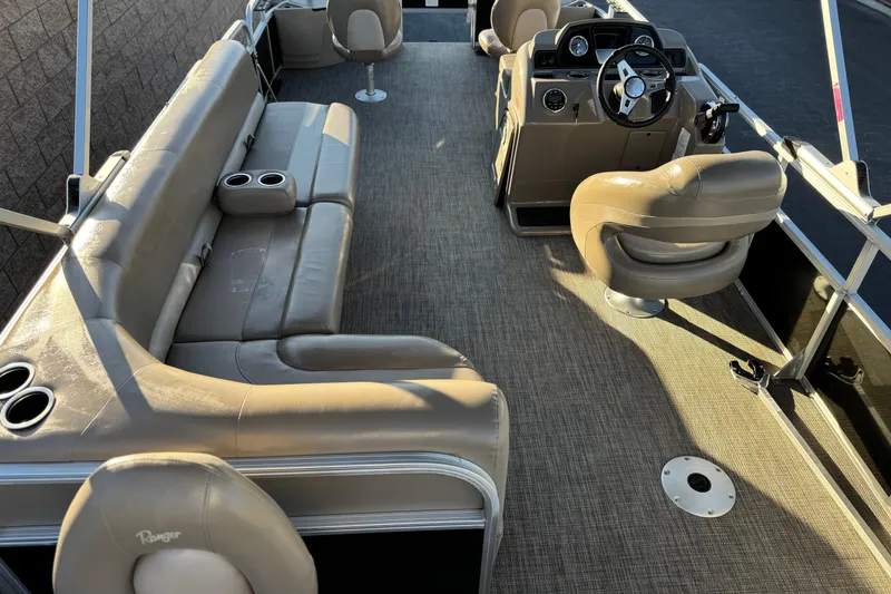 Slide: The Image of 2023 Ranger Reata 200F boat interior with beige seating and steering console. - 23