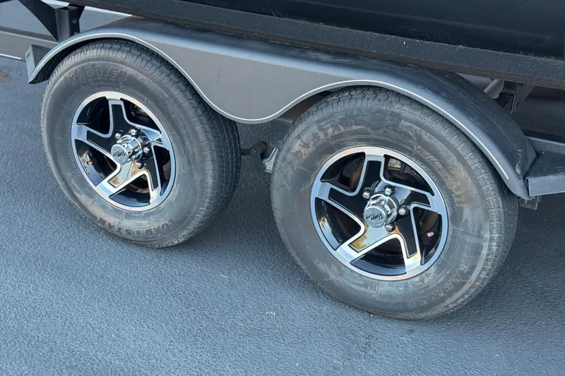Slide: The Image of 2023 Ranger Reata 200F trailer wheels with chrome rims on asphalt surface. - 28
