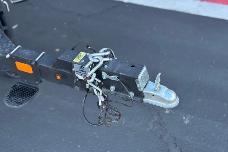 Slide: The Image of Trailer hitch of 2023 Ranger Reata 200F with safety chains and coupler on asphalt. - 29