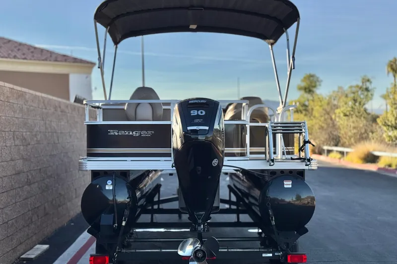 Slide: The Image of 2023 Ranger Reata 200F pontoon boat with Mercury 90 engine, parked outdoors. - 5