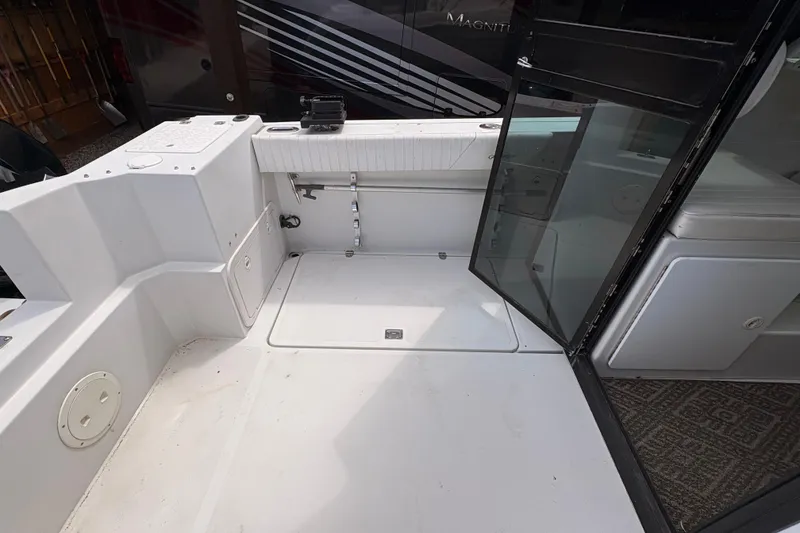 Slide: The Image of 2001 Glacier Bay 2690 Coastal Runner boat interior with open glass door and storage compartments. - 21