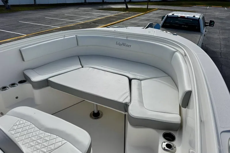 Slide: The Image of 2014 Edgewater 280CC boat interior with white seating and cup holders. - 10