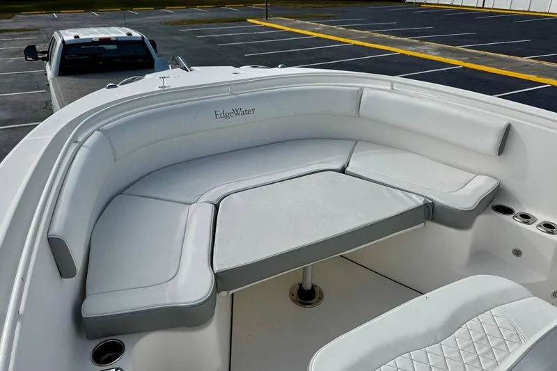 Slide: The Image of 2014 Edgewater 280CC boat with cushioned seating and cup holders in a parking lot. - 11