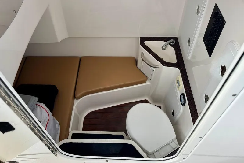Slide: The Image of 2014 Edgewater 280CC cabin interior with toilet, sink, and seating area. - 16