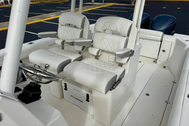 Slide: The Image of 2014 Edgewater 280CC boat interior with luxurious white seating and steering wheel. - 18