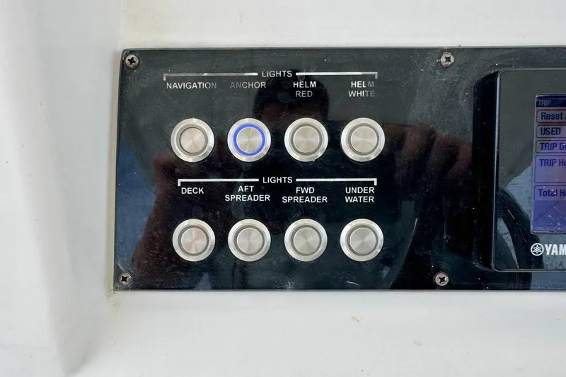Slide: The Image of Control panel of a 2014 Edgewater 280CC boat with various light switches. - 26