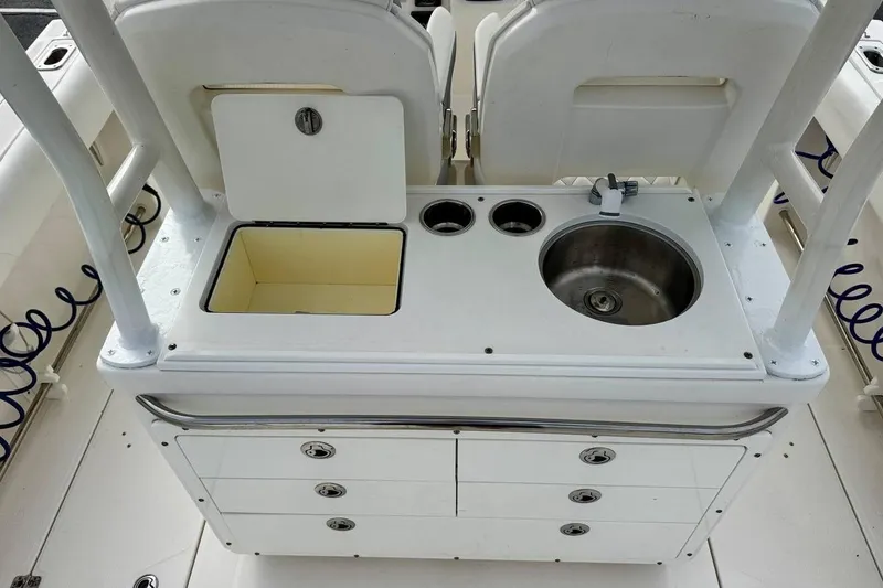 Slide: The Image of 2014 Edgewater 280CC boat interior with sink, storage, and cup holders. - 35