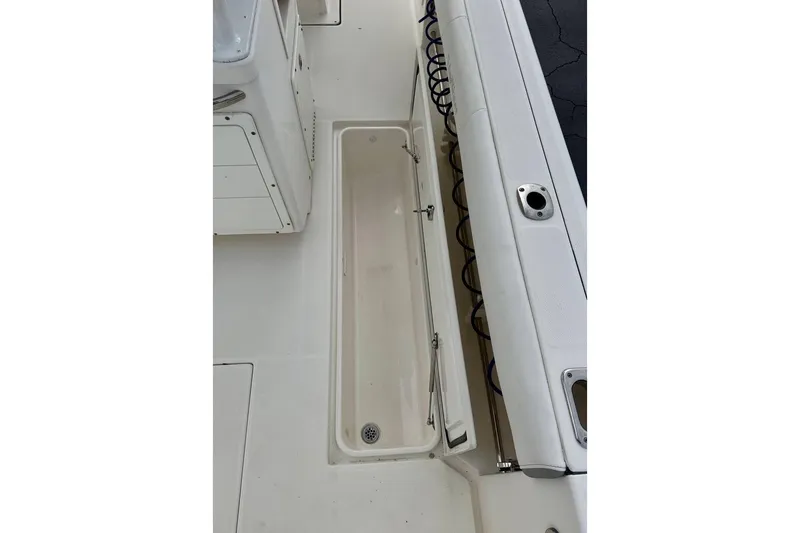 Slide: The Image of 2014 Edgewater 280CC boat deck with storage compartment and rod holders. - 41