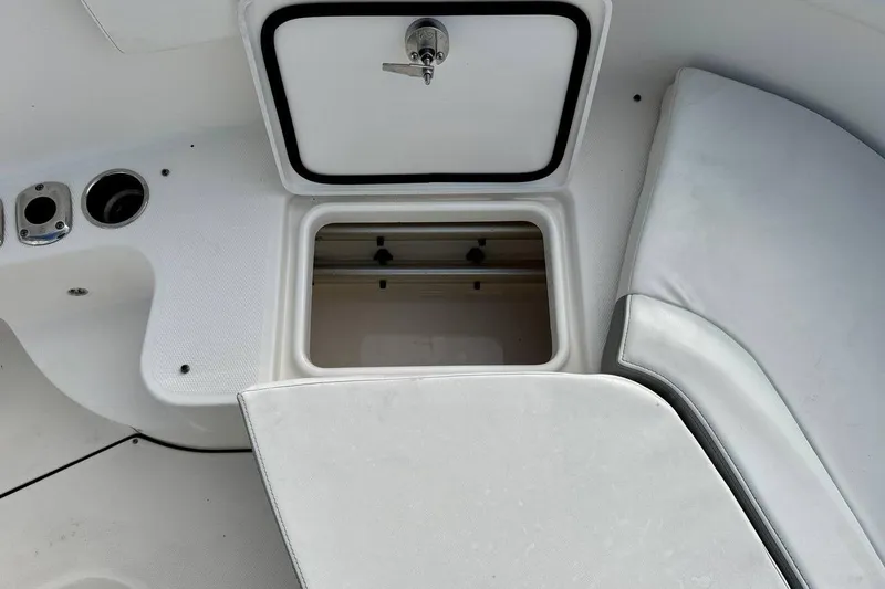 Slide: The Image of 2014 Edgewater 280CC boat storage compartment with open hatch and cushioned seating. - 44