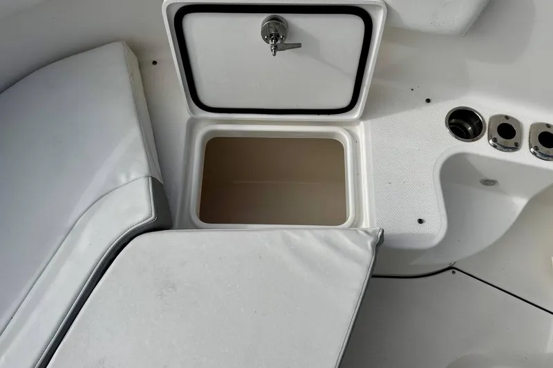 Slide: The Image of 2014 Edgewater 280CC boat storage compartment with open lid and seating area. - 45