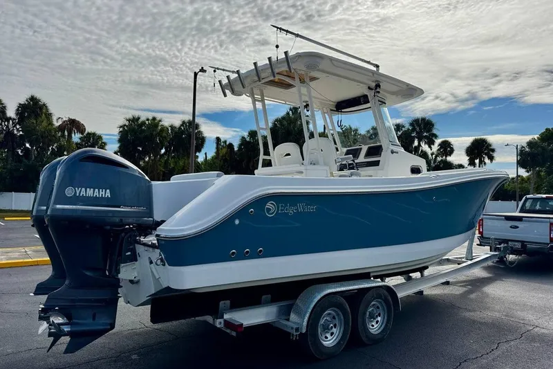 Slide: The Image of 2014 Edgewater 280CC boat on trailer with Yamaha engines, parked outdoors. - 5