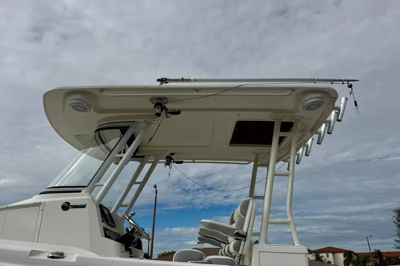 Slide: The Image of 2014 Edgewater 280CC boat with T-top and rod holders under cloudy sky. - 50
