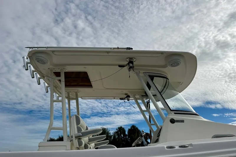 Slide: The Image of 2014 Edgewater 280CC boat with T-top against a cloudy sky background. - 51