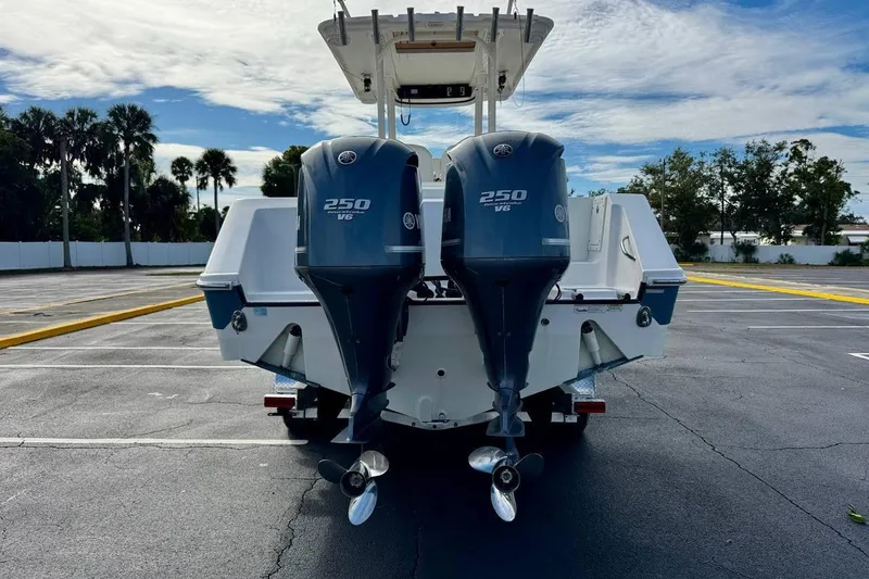 Slide: The Image of 2014 Edgewater 280CC boat with dual Yamaha 250 V6 engines in a parking lot. - 6
