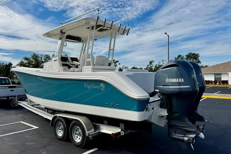 Slide: The Image of 2014 Edgewater 280CC boat with Yamaha engines on a trailer, parked outdoors. - 7