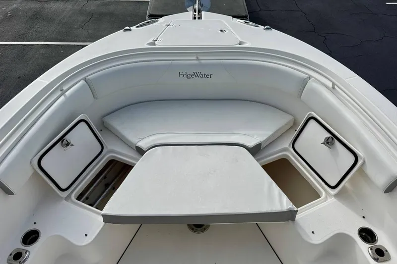 Slide: The Image of 2014 Edgewater 280CC boat interior with cushioned seating and storage compartments. - 9