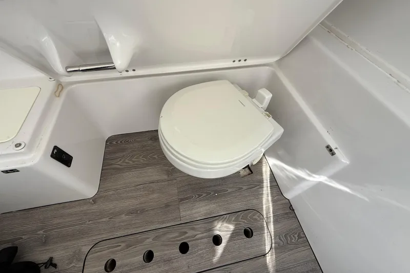 Slide: The Image of 2020 Sportsman Open 352 Center Console boat bathroom with toilet and wood-patterned flooring. - 31