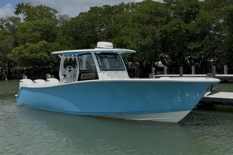 Slide: The Image of 2020 Sportsman Open 352 Center Console boat in calm waters, surrounded by lush greenery. - 50