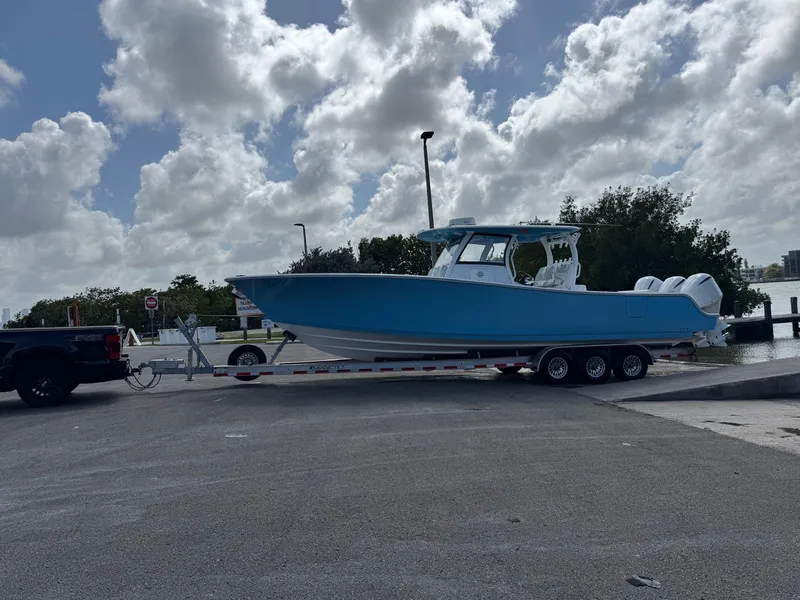 Slide: The Image of 2020 Sportsman Open 352 Center Console boat on trailer at a dock under cloudy sky. - 52