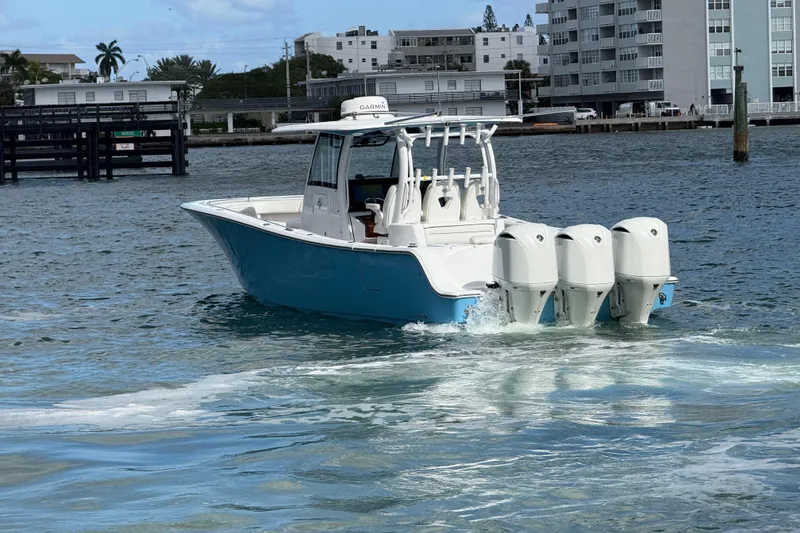 Slide: The Image of 2020 Sportsman Open 352 Center Console boat cruising on water near urban buildings. - 56