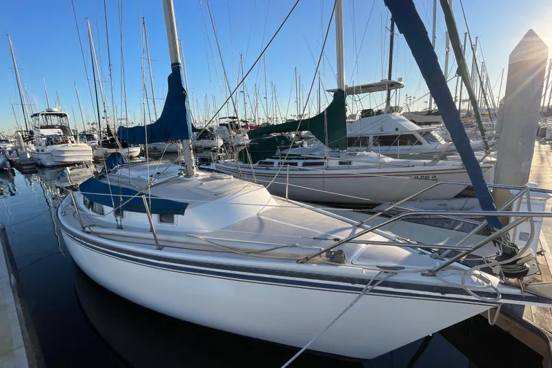 Slide: The Image of Sailboat Newport 30, 1987 model, docked in a marina with other boats. - 1