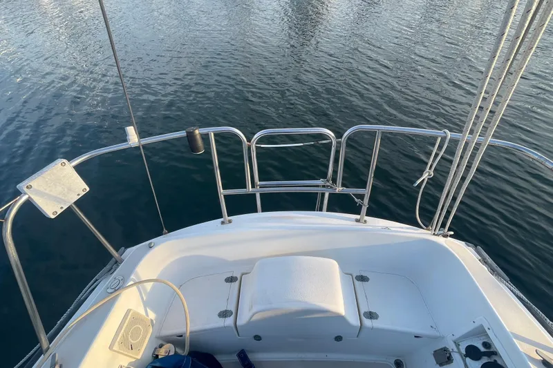 Slide: The Image of 1987 Newport 30-3 sailboat stern view with railing and calm water. - 4