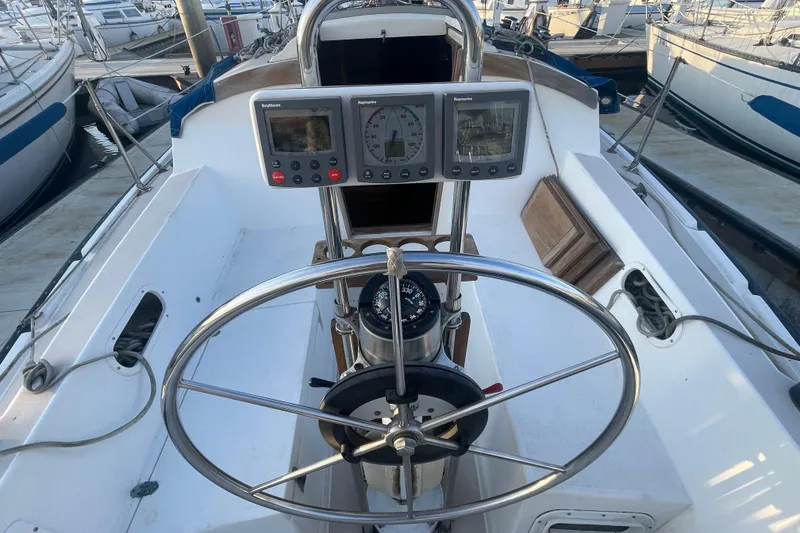 Slide: The Image of Cockpit of 1987 Newport 30-3 sailboat with steering wheel and navigation instruments. - 6