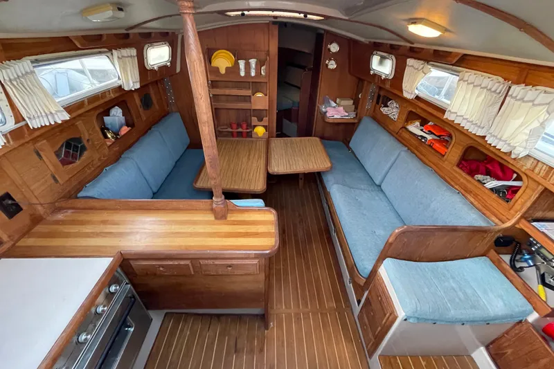 Slide: The Image of Interior of 1987 Newport 30-3 sailboat with wooden furnishings and blue seating. - 8