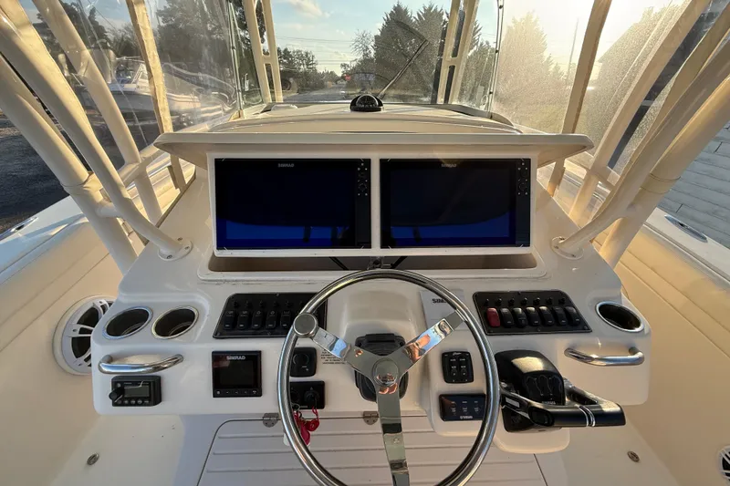 Slide: The Image of 2017 Grady-White Canyon 336 helm with dual Simrad displays and steering wheel. - 18