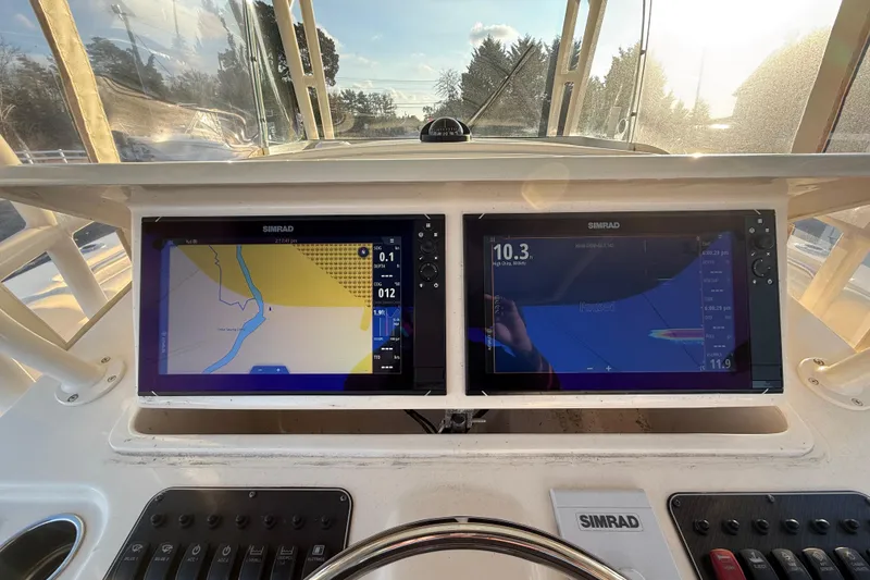 Slide: The Image of 2017 Grady-White Canyon 336 boat dashboard with dual Simrad navigation displays. - 23