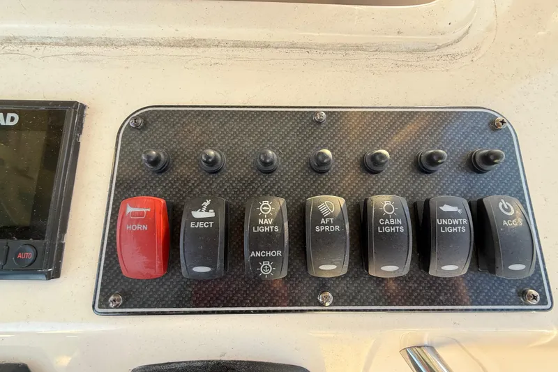 Slide: The Image of Control panel of a 2017 Grady-White Canyon 336 boat with labeled switches. - 26