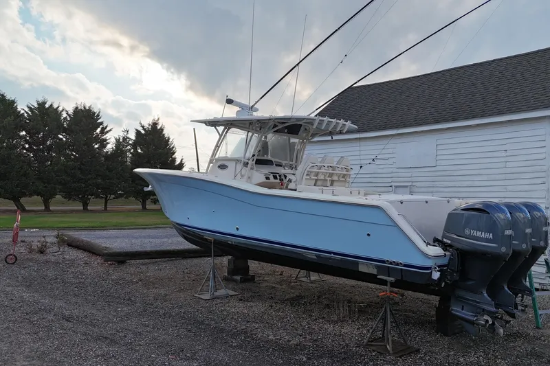 Slide: The Image of 2017 Grady-White Canyon 336 boat with Yamaha engines on a stand, near a white building. - 3