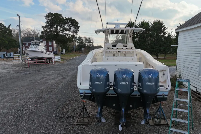Slide: The Image of 2017 Grady-White Canyon 336 boat with triple Yamaha engines on a gravel lot. - 4