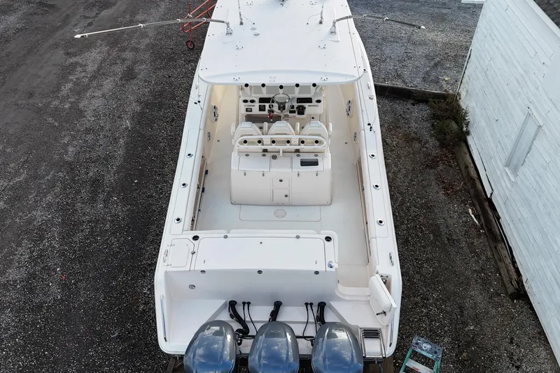 Slide: The Image of 2017 Grady-White Canyon 336 boat, aerial view, triple engines, white interior, docked on gravel. - 5