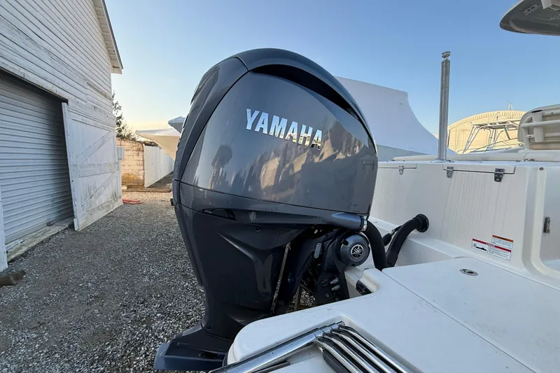 Slide: The Image of 2023 Grady-White Fisherman 236 with Yamaha outboard motor, parked near a building. - 22