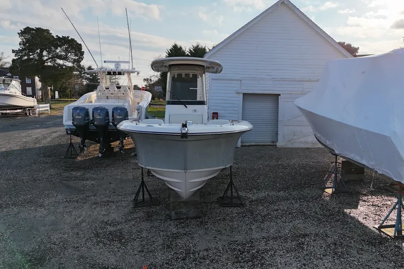 Slide: The Image of 2023 Grady-White Fisherman 236 boat on stands near a white building. - 3