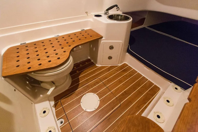 Slide: The Image of Manufacturer Provided Image: 2019 Grady-White Canyon 336 boat interior with wooden flooring and compact bathroom. - 17
