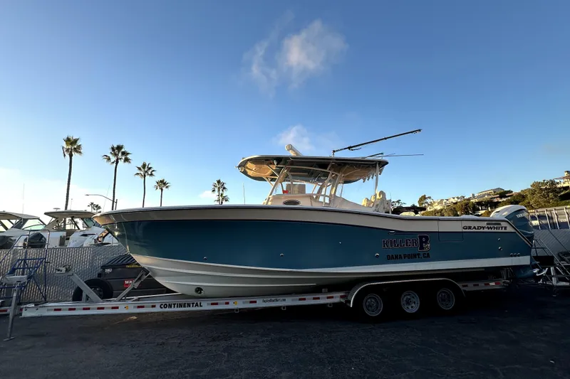 Slide: The Image of 2019 Grady-White Canyon 336 boat on trailer, palm trees in background, clear sky. - 3